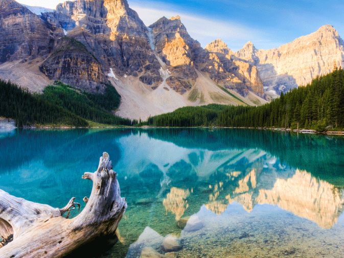 Delle montagne si specchiano in un lago nel Parco naturale Banff, da raggiungere in sicurezza con un’assicurazione viaggio Canada