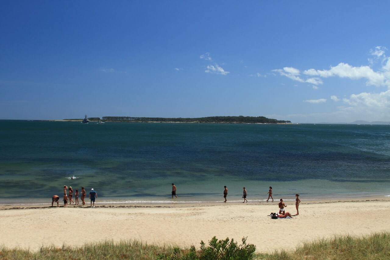 Turisti in spiaggia guardano l'Isla Gorriti. Cosa vedere in un viaggio in Uruguay?