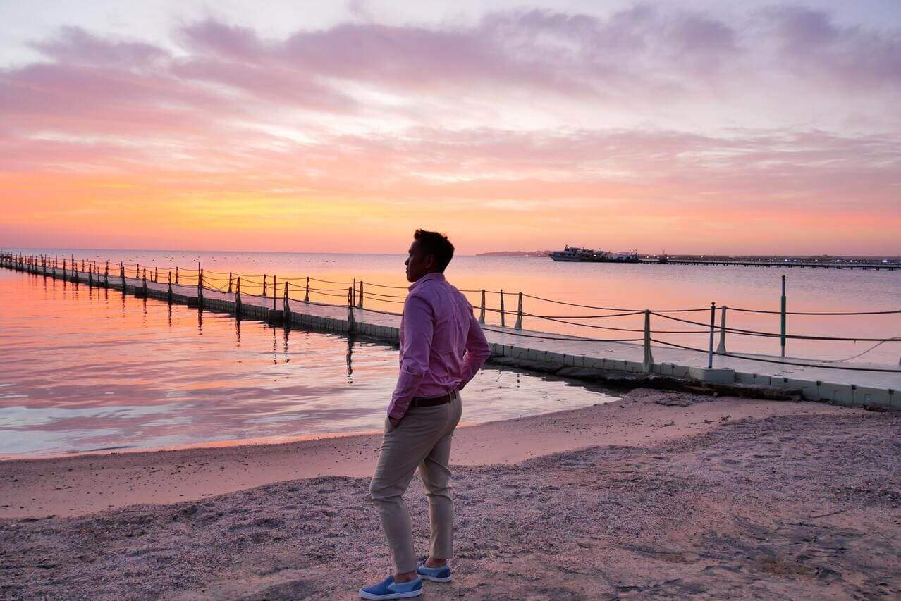 Un uomo osserva il tramonto sulla spiaggia di Hurghada, in Egitto.