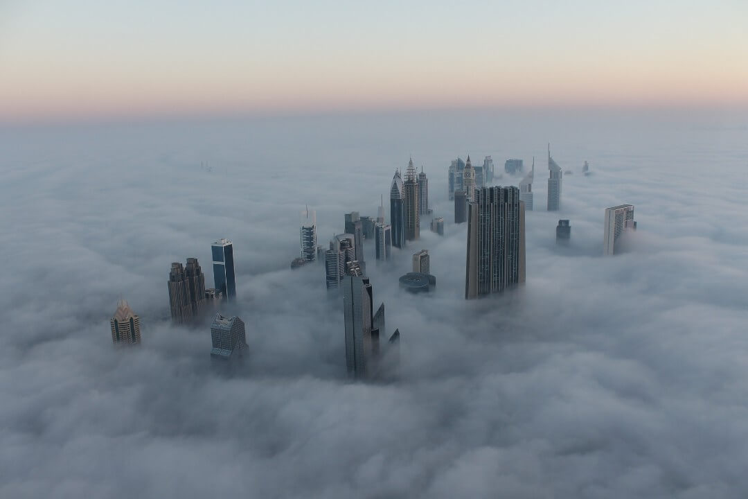 Le cime dei grattacieli di Dubai che spuntano dalle nuvole.