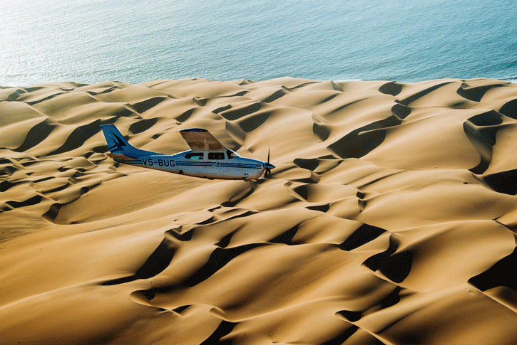 Un aeroplano monoelica sorvola la Skeleton Coast in Namibia.