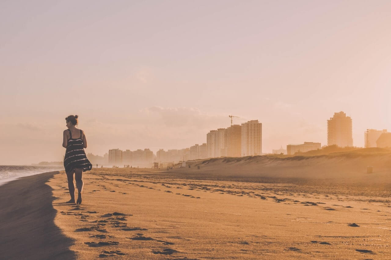 Una turista cammina sulla spiaggia di Punta del Este, in Uruguay.
