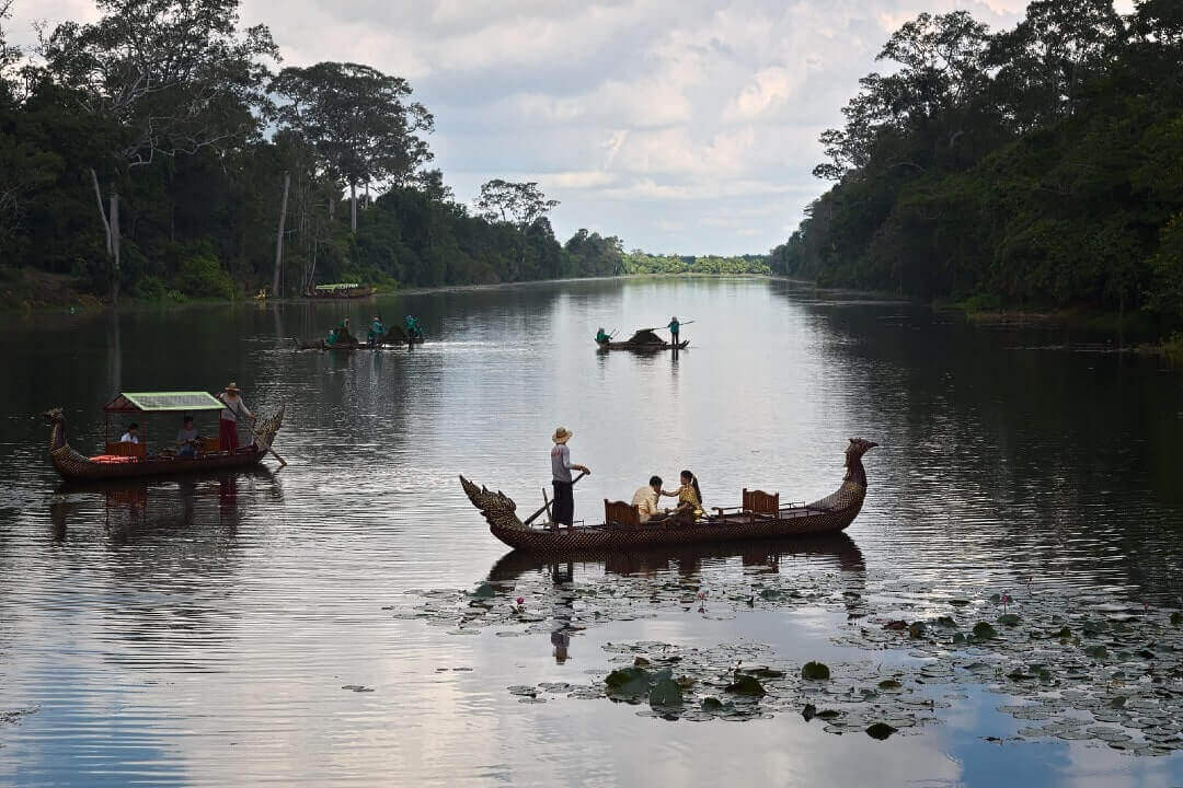Una barca tipica galleggia sul fiume in Cambogia. I motivi per un'assicurazione viaggio Cambogia.