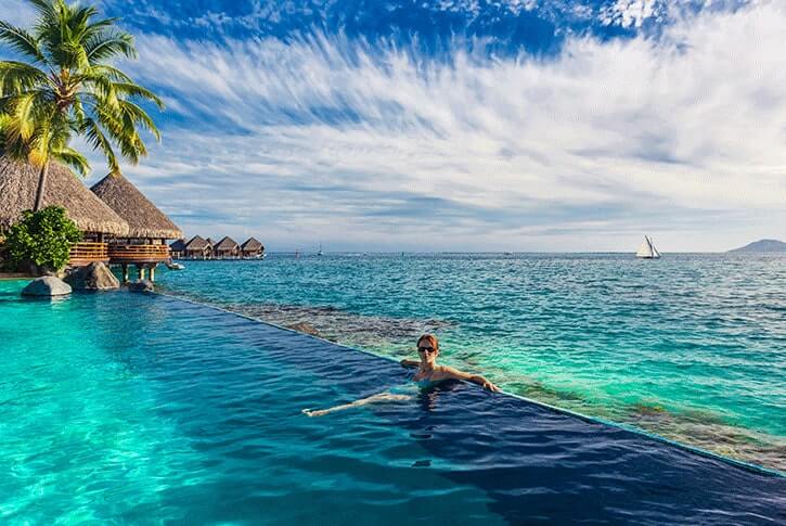 Una turista si gode il mare e la vacanza a Tahiti.