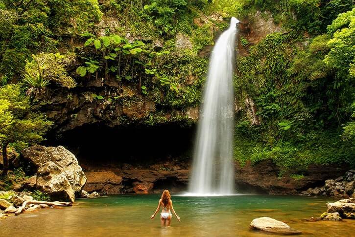 Una turista fa il bagno presso le Cascate di Tavoro sull'isola Taveuni, nelle Fiji.