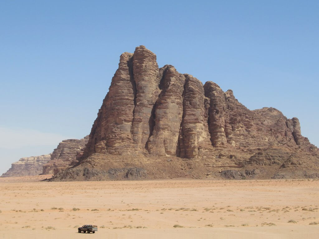 Una jeep percorre il deserto del Wadi Rum passando davanti alle Sette meraviglie del mondo, Giordania.