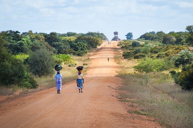 Due donne in cammino lungo le strade sterrate del Mozambico. Segui i consigli di viaggio di Amerigo.it