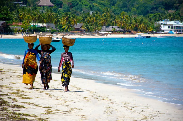 Tre donne camminano in riva al mare in Madagascar. Scopri quando e dove andare con Amerigo.it
