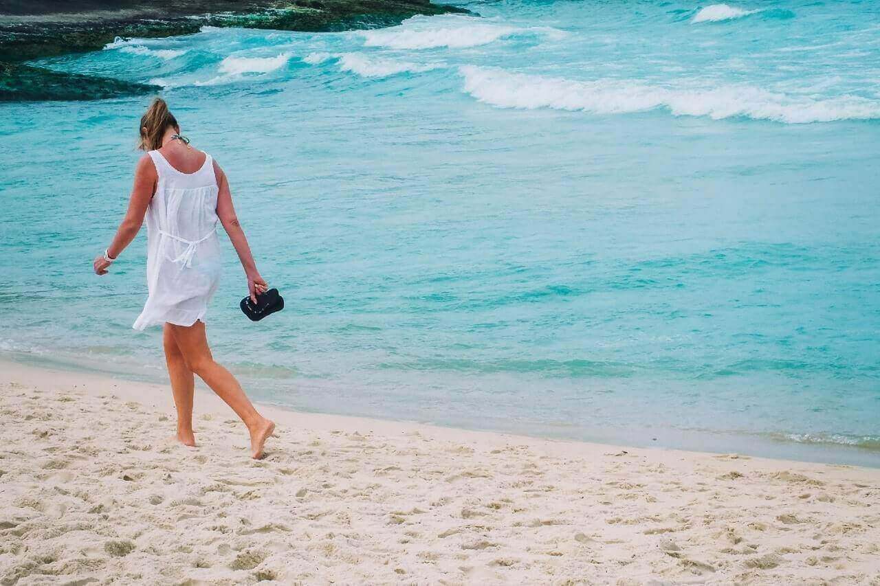 Una donna passeggia lungo la spiaggia di Ipanema, a Rio de Janeiro, Brasile.