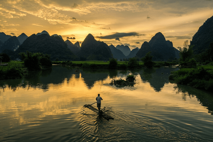 Un uomo su un'imbarcazione guarda il panorama naturale che ha di fronte: scegliere cosa vedere in Vietnam è difficile