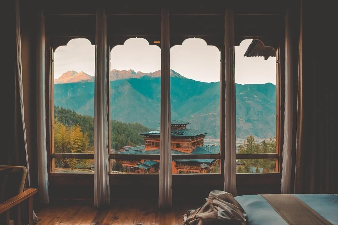Vista del panorama montuoso del Bhutan attraverso una finestra di albergo.