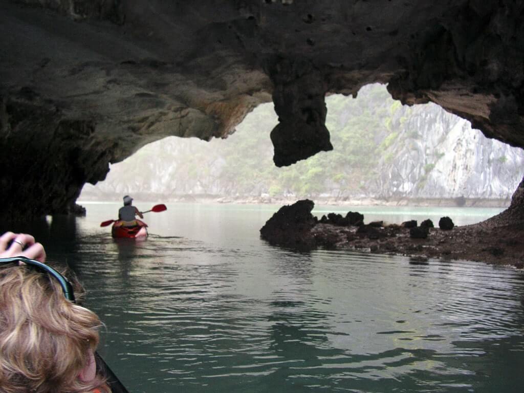Delle persone visitano le grotte dell’Isola di Cat Ba, navigando sul mare con le canoe.